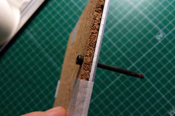 Tornillo de métrica 3 de 40 mm pasado por su hueco ( cama y corcho)