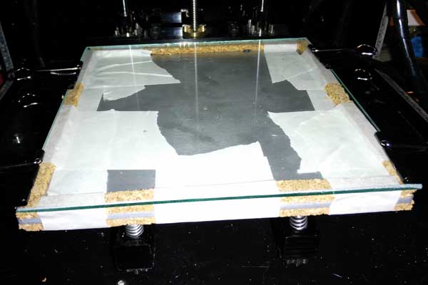 Cama caliente terminada, los tornillos sujetos con las tuercas y el cristal con cuatro clips de papelería